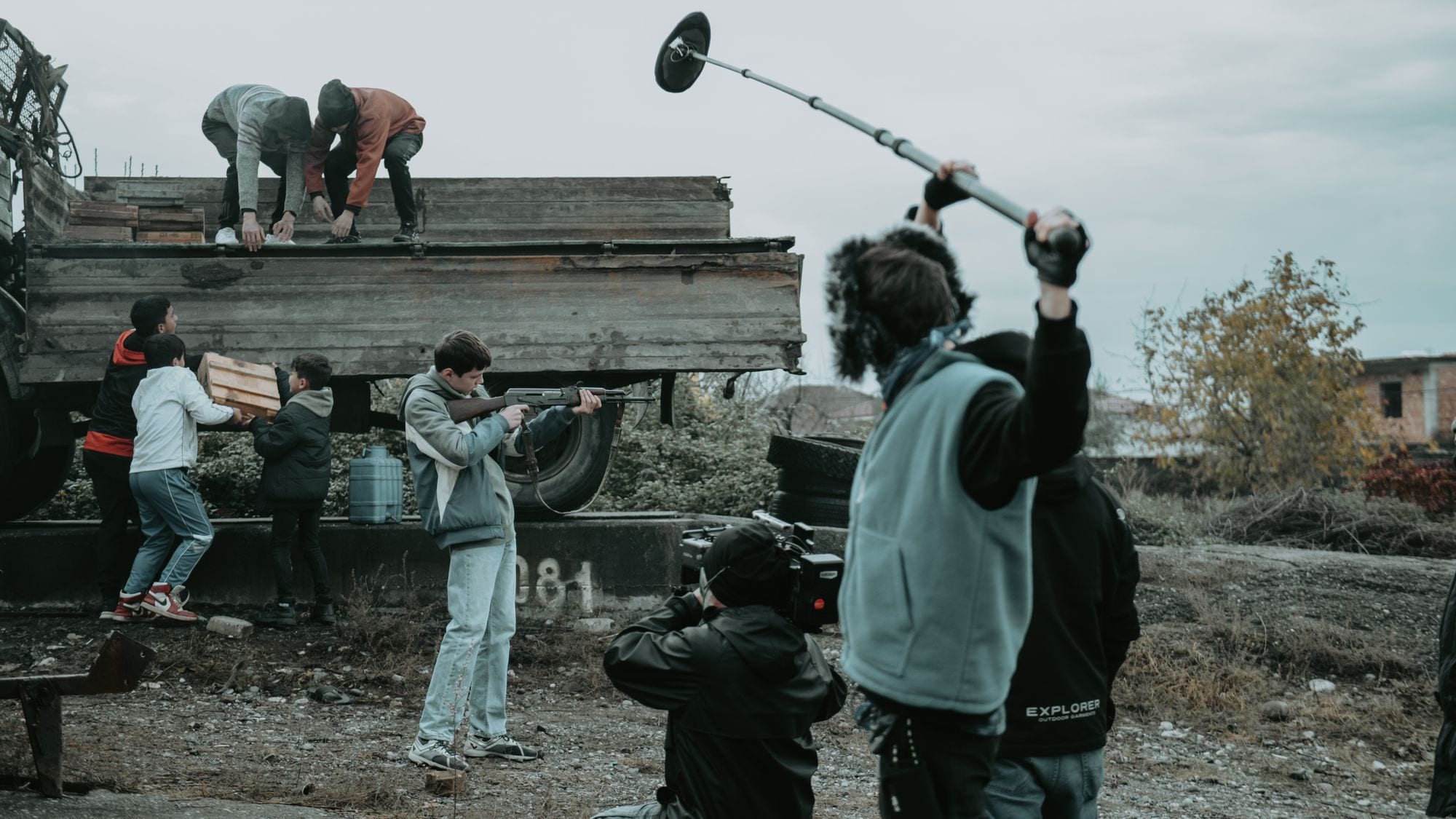 Filmcrew bei Außenaufnahmen mit Kamera und Tonangel an einem grauen Tag.